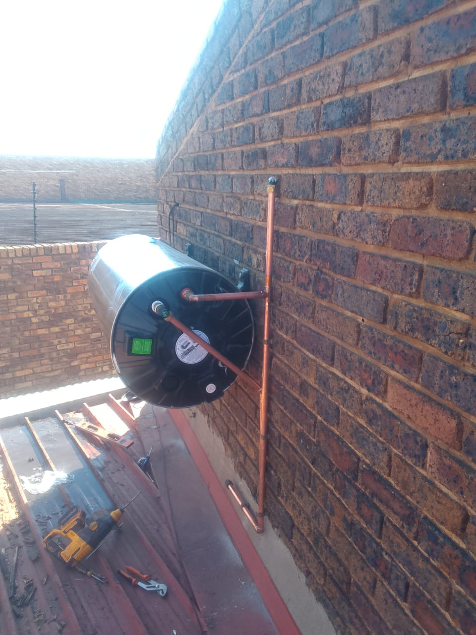 Technician installing a solar water heater on a rooftop in Pretoria