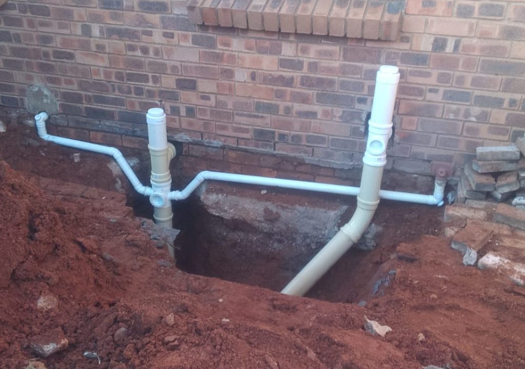 Exposed pipes and new drainage installation during sewer repair