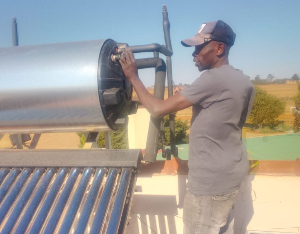 Technician installing a new solar geyser on a rooftop in Pretoria